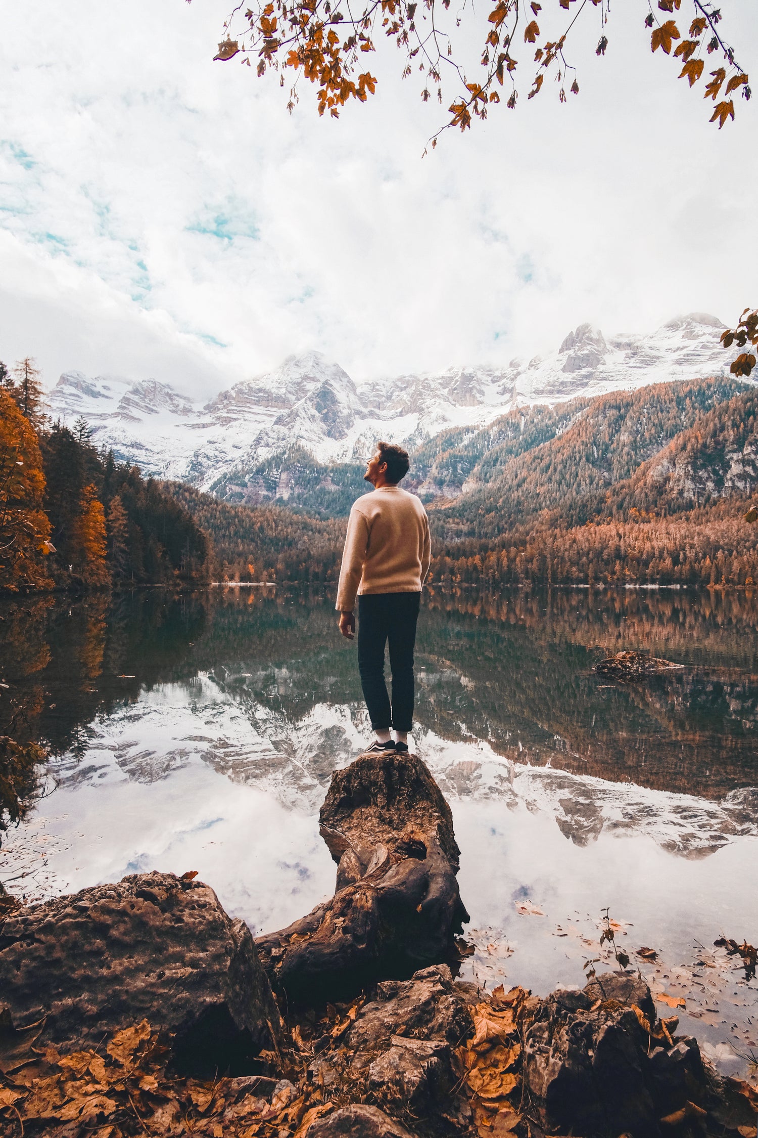Person on the waterfront looking at white mountains.